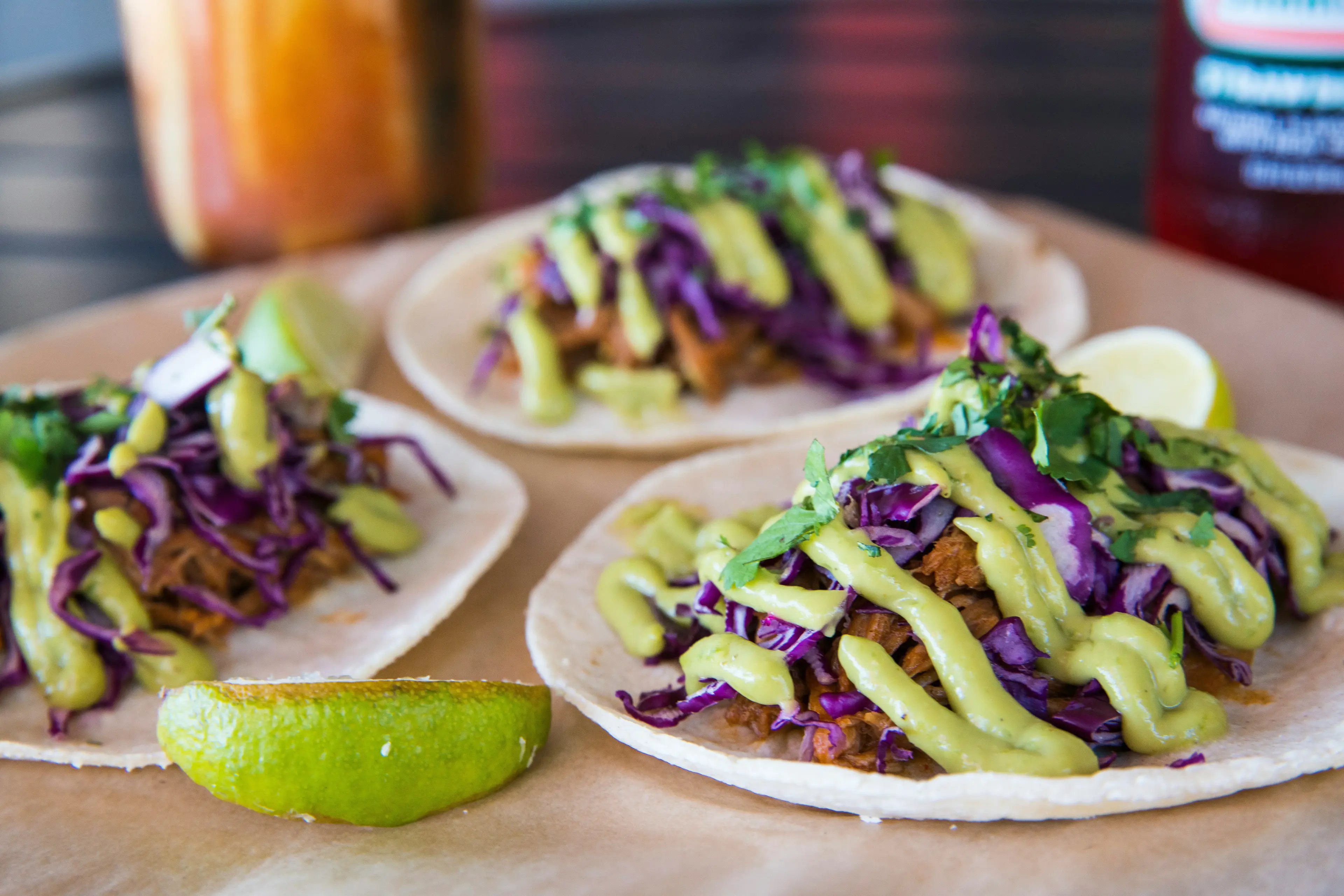 Colorful tacos with cabbage and avocado crema