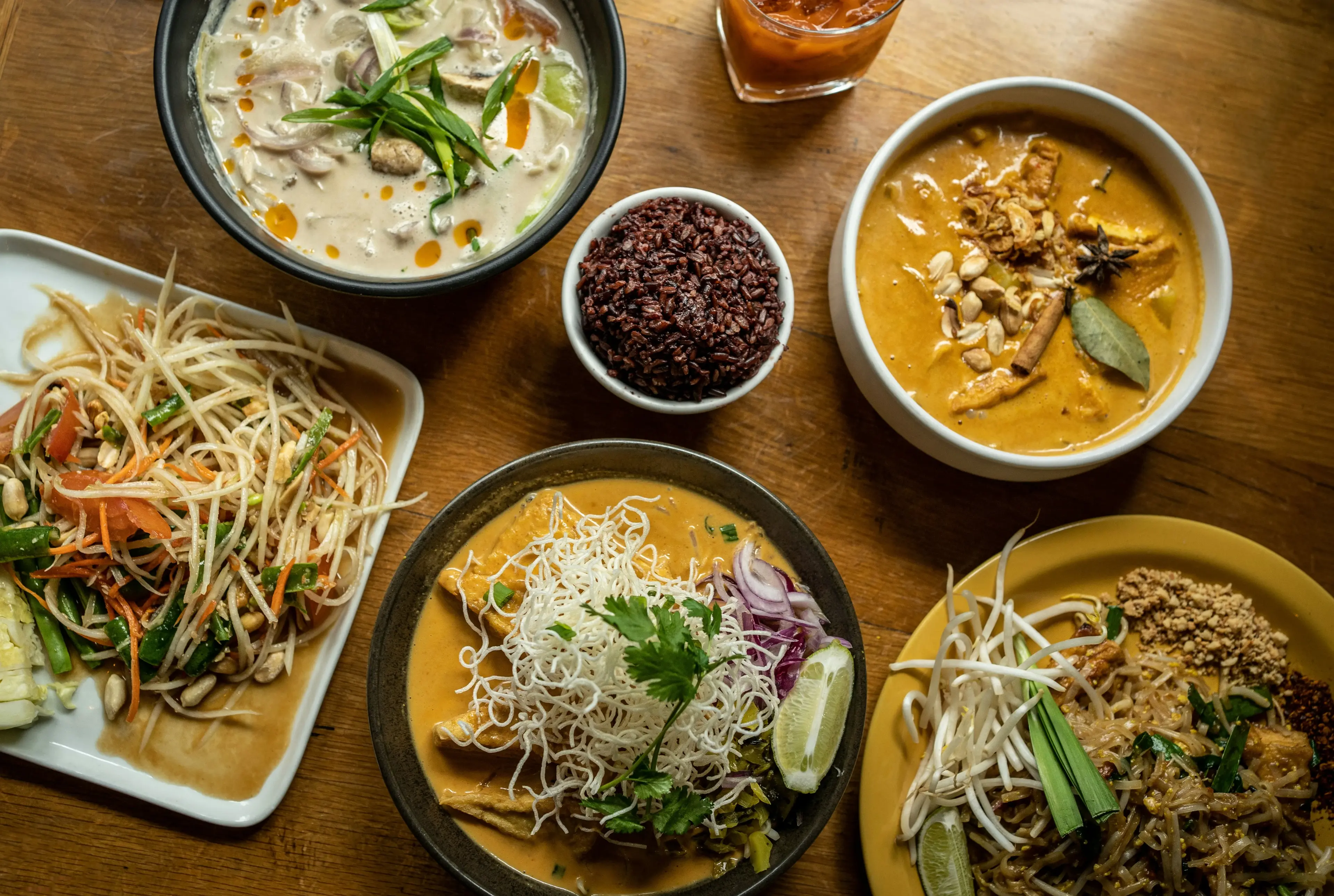 Thai curry, pad Thai, and noodle dishes on a table