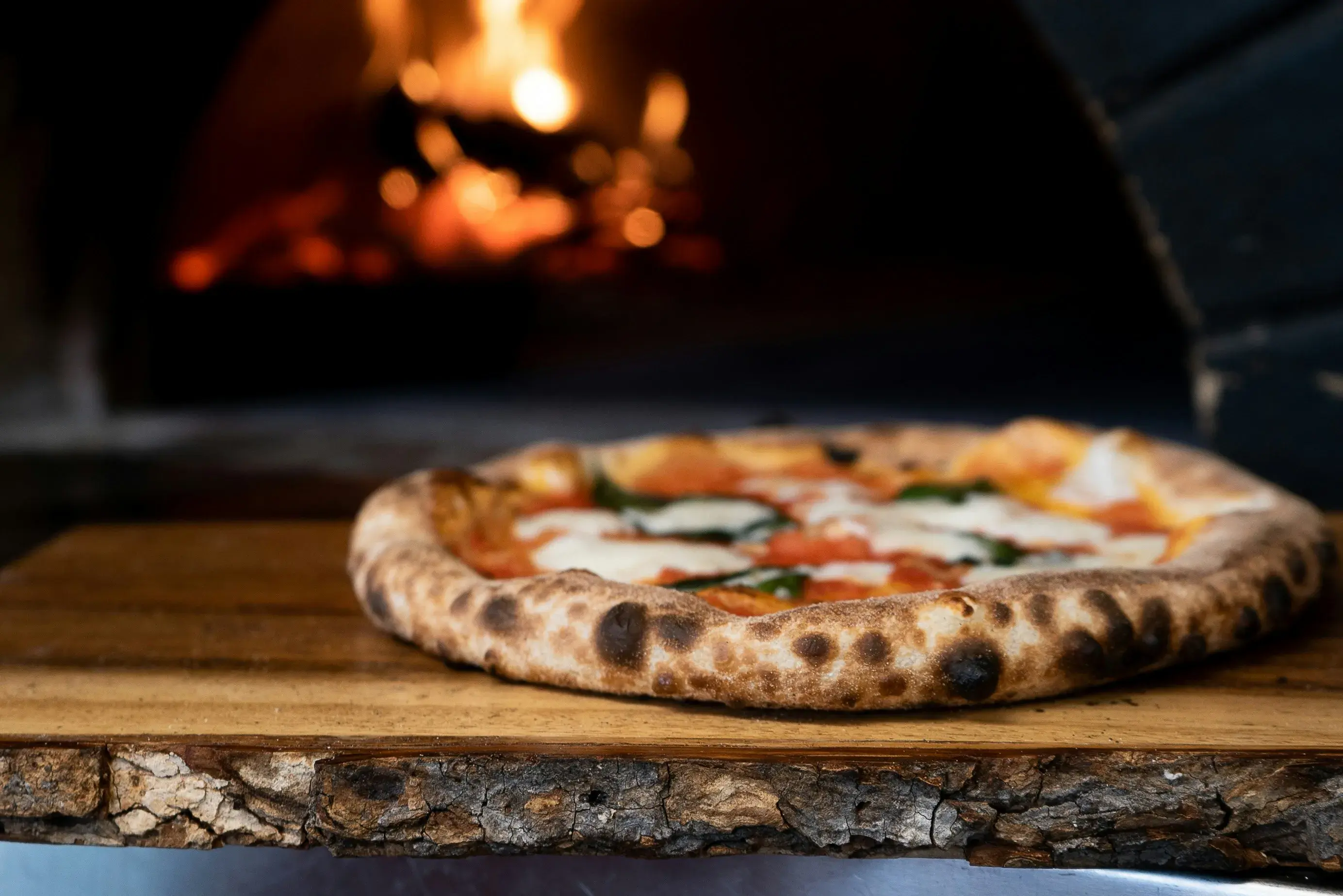 Wood-fired margherita pizza on a rustic board