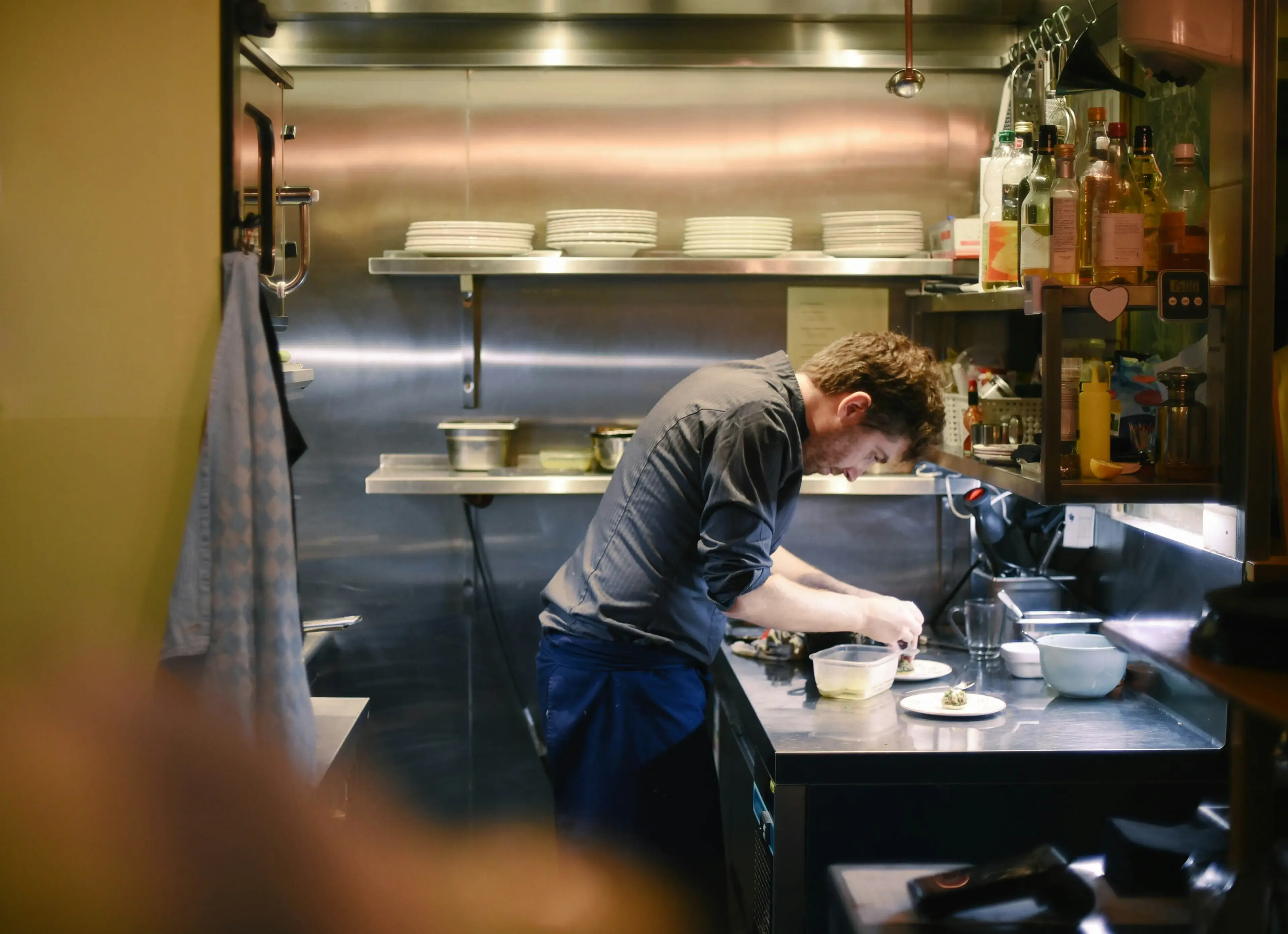 Chef plating a dish in an open kitchen