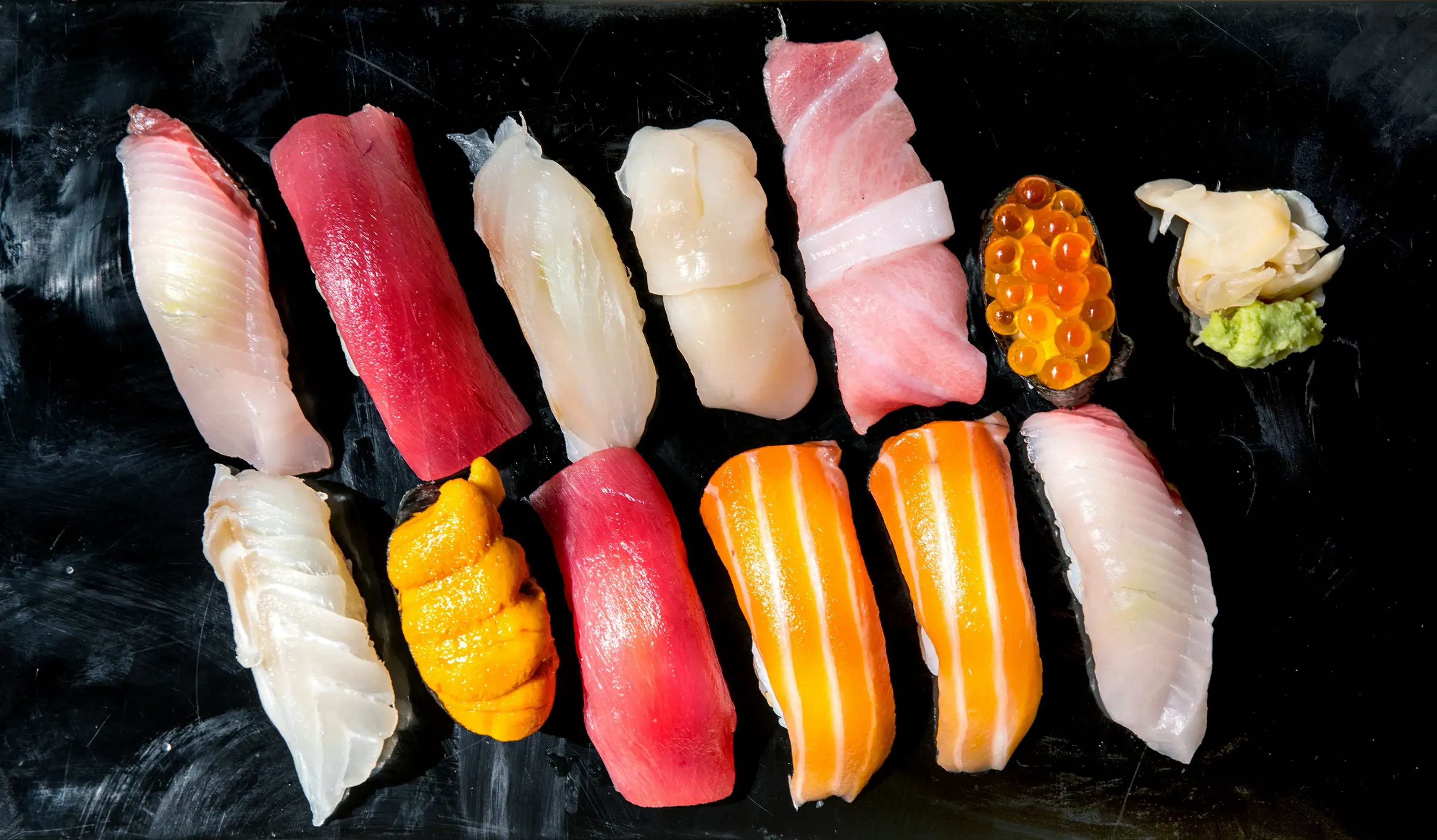 Omakase nigiri sushi on a dark plate