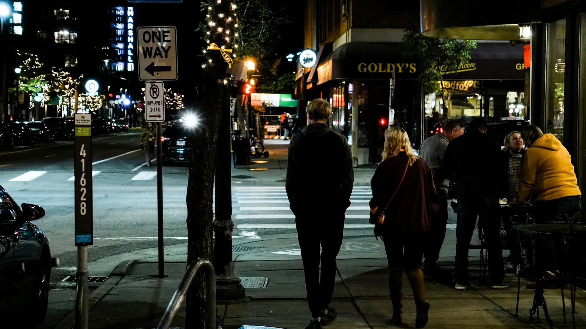 Residential street in Lowry Hill East (The Wedge) neighborhood of Minneapolis with dense apartment buildings and tree-lined sidewalks